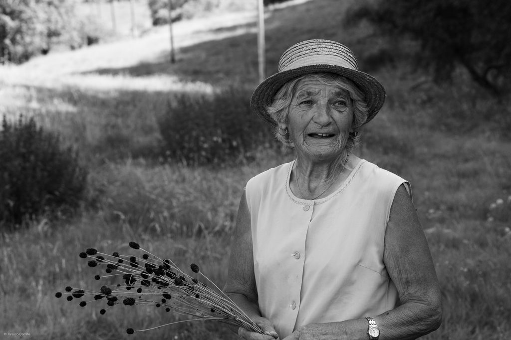Portrait en noir et blanc d’une femme âgée avec un chapeau