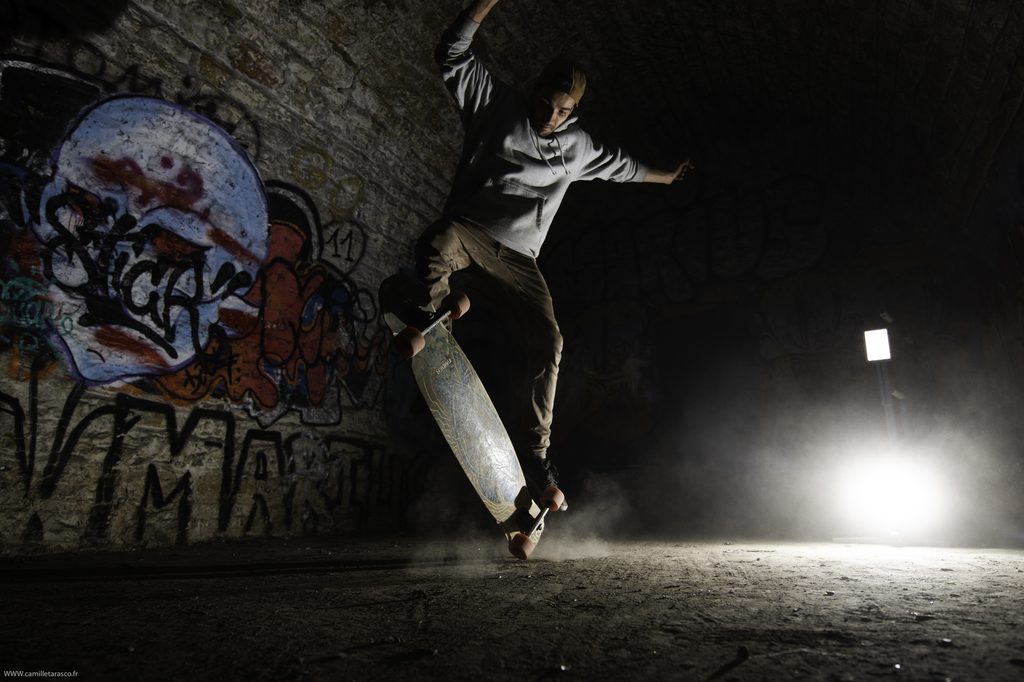 Skateur réalisant une figure dans un lieu couvert de graffitis