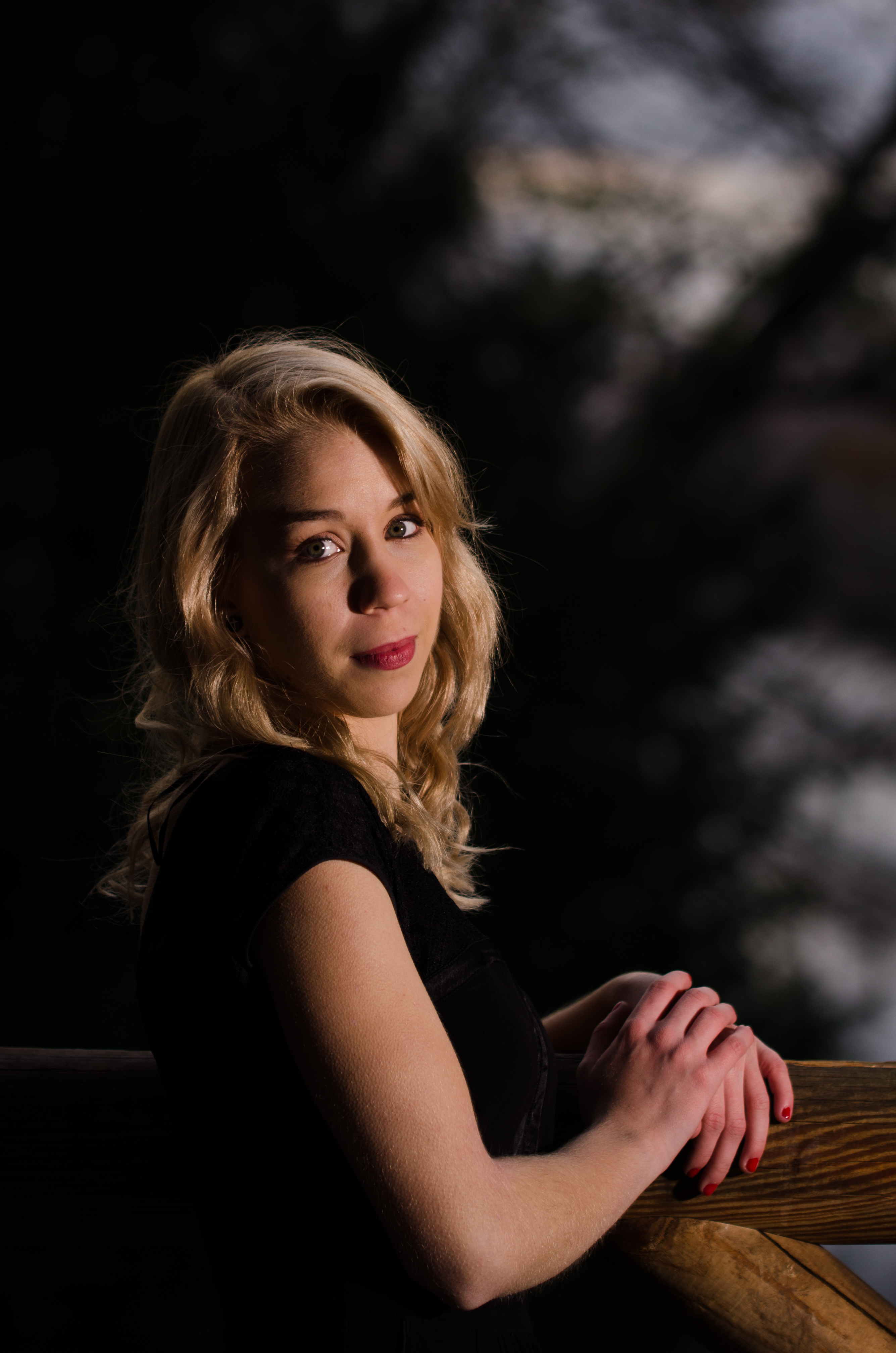 Jeune femme blonde appuyée sur une rambarde
