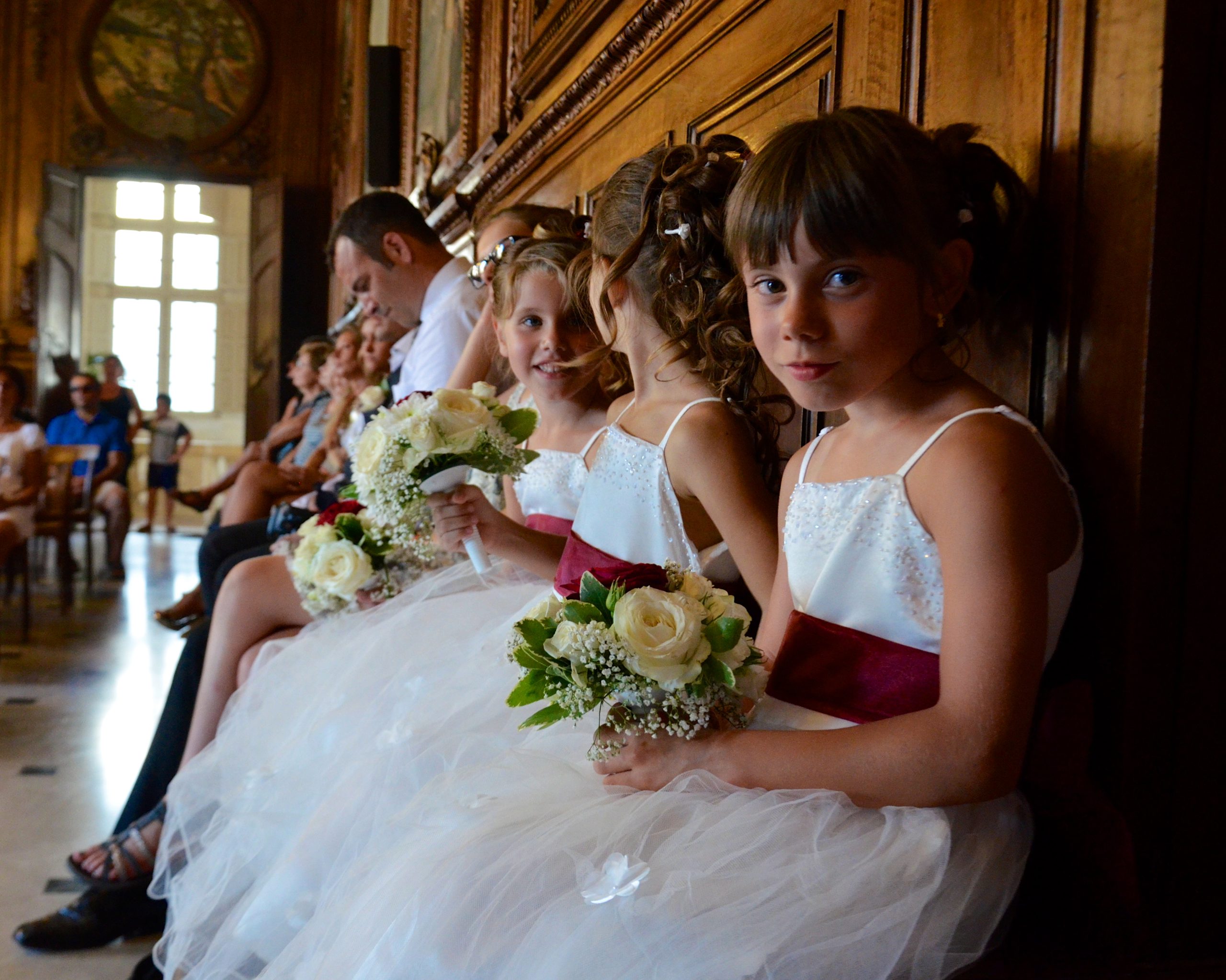 Demoiselles d’honneur assises avec leurs bouquets pendant un mariage