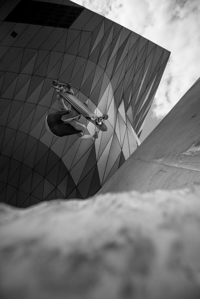 Skateur en plein saut devant une architecture contemporaine