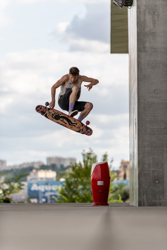 Skateur réalisant un saut près d’un pilier en béton