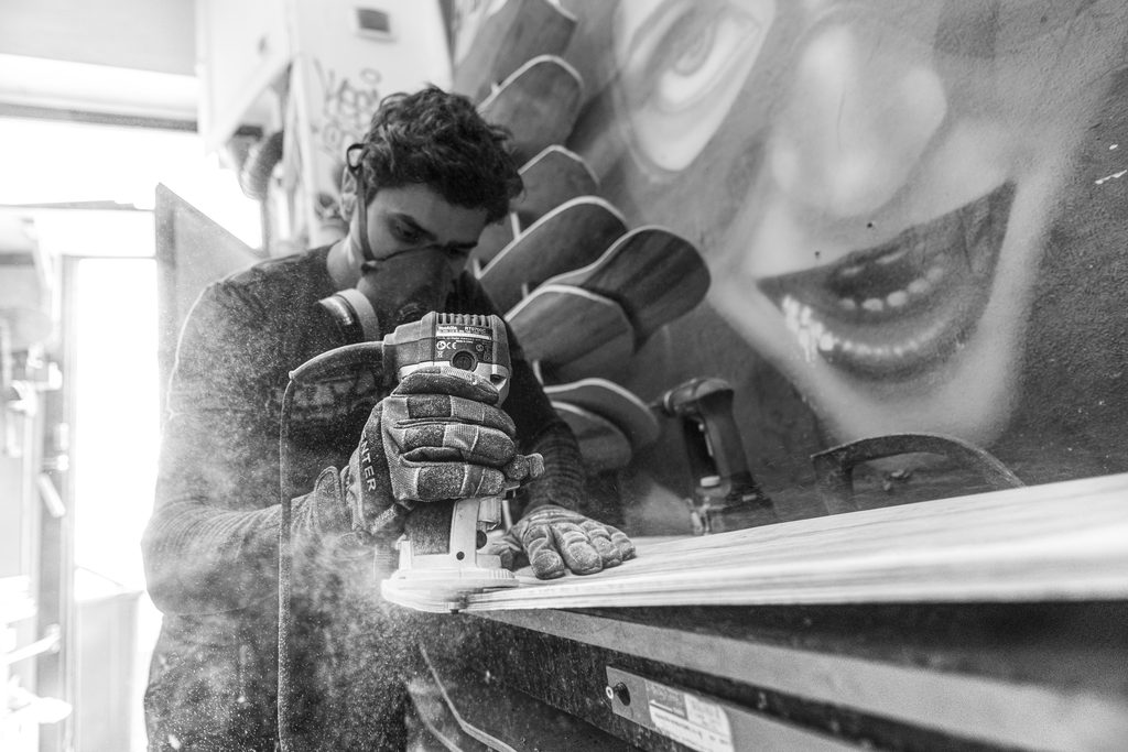 Artisan façonnant une planche en bois, en noir et blanc