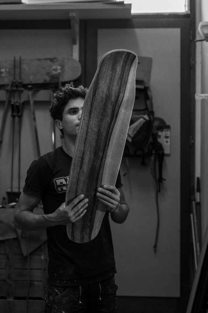 Artisan tenant une planche en bois dans son atelier