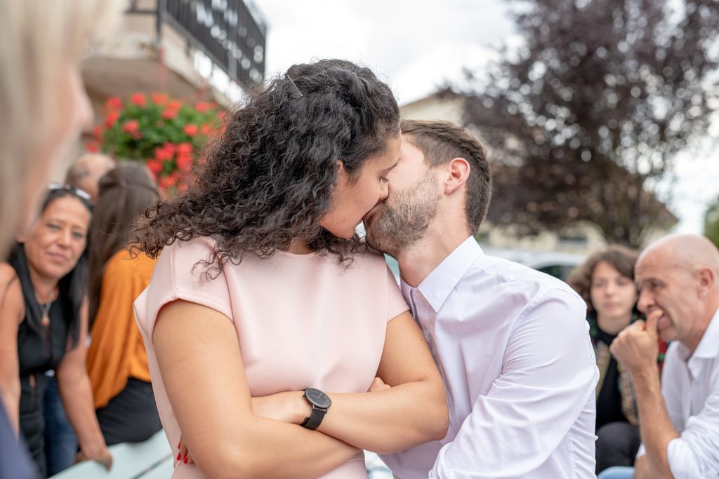 Couple s’embrassant parmi les invités